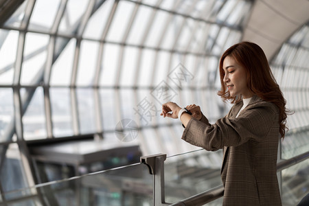 在机场等待飞行和寻找智能手表的美女图片