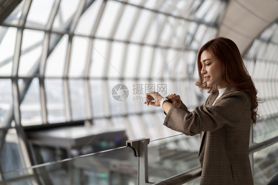 在机场等待飞行和寻找智能手表的美女图片