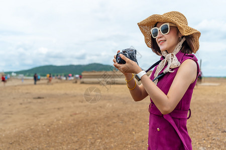 旅行妇女在农村拍摄带有相机的片图片