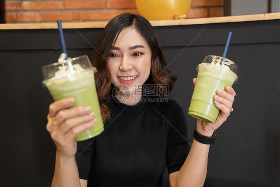 女人在咖啡厅里喝抹茶图片