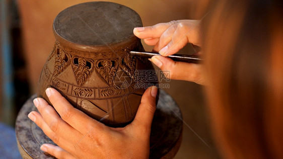 手使陶器在土上造成装饰图案图片
