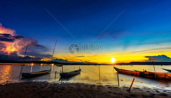 泰国NahonRatchasima省Khonburi河岸有日落和闪电的木船图片