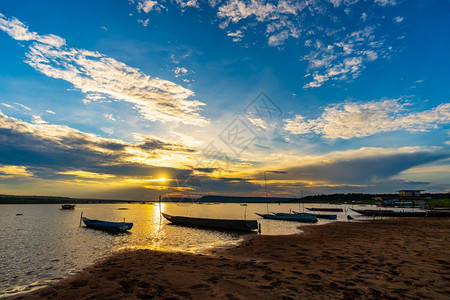 木船在河的岸边与日落在孔武里纳洪省泰国图片
