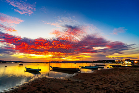 木船在河的岸边与日落在孔武里纳洪省泰国图片