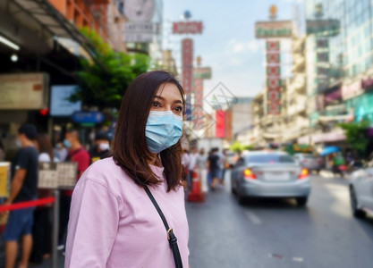 在曼谷唐人街的亚瓦拉特公路上戴面罩的年轻妇女图片