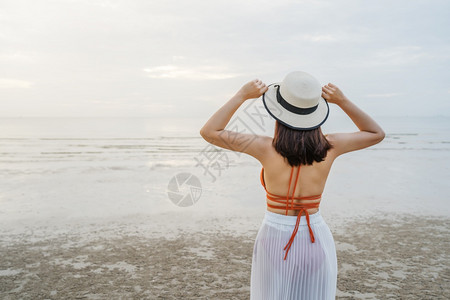 快乐的比基尼女人站在海边的图片