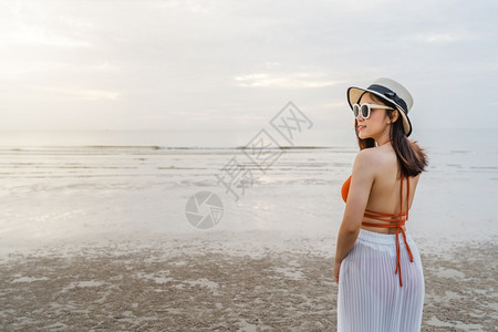 快乐的比基尼女人站在海边的图片