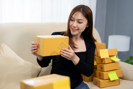 青年女企业家在庭办公室准备包裹箱中小型企业务图片