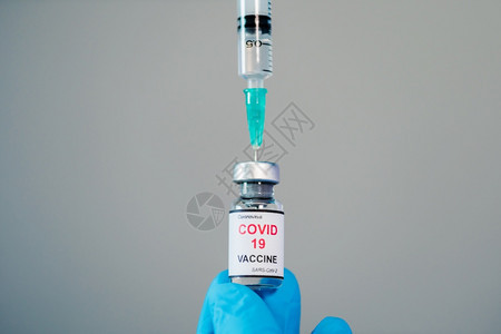 医生亲手将科罗纳新冠疫苗瓶提取到注射器药物中图片