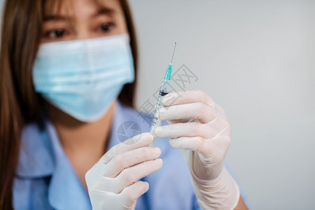 持有新冠新冠注射测试疫苗针管的女医生图片