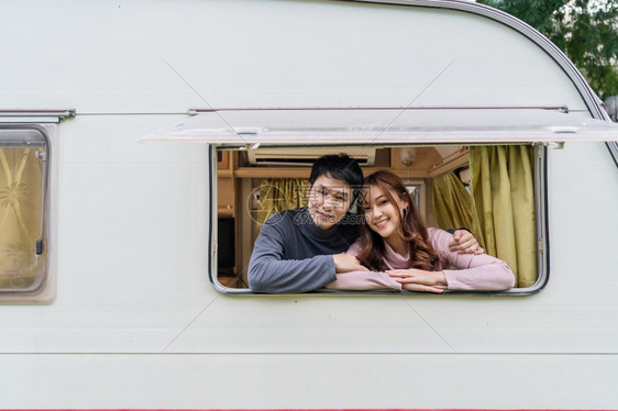 一对快乐的年轻夫妇在露营车RV面包马的窗口图片