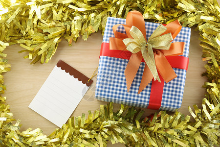 在装饰品木地板上的蓝礼品盒在圣诞和新年的概念中贴在纸上图片