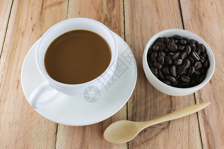 白咖啡杯和木制勺子放在背景上图片