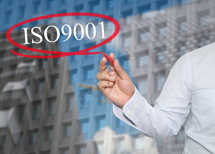 年轻商人的手在摩天大楼背景应用概念上写了ISO901字以促进你的业务或工作介绍图片