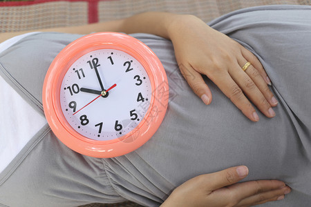 孕妇在肚子上显示时钟背景图片