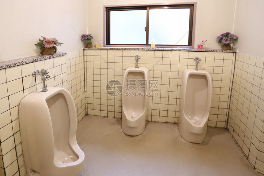 公共男子浴室的白色小便池图片