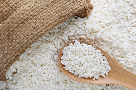 木勺和袋中的有机白米、谷类大或用于设计自然食品的粘糊米。图片