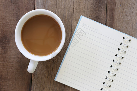 白咖啡杯和笔记本放在旧木地板上设计咖啡因饮料图片