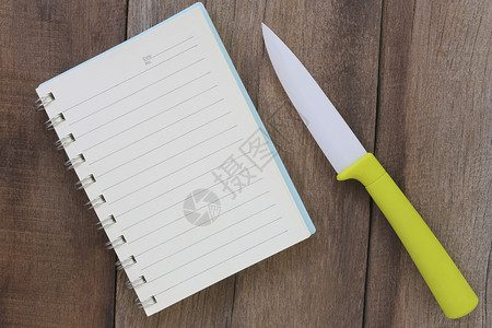 把笔记本和丙烯刀放在老木地板上刀的设计概念不是生锈的图片