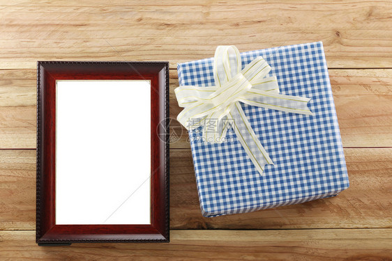在圣诞和新年的概念下在木地板上布朗框附近的蓝礼盒图片