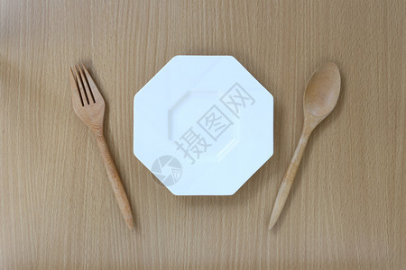 木制勺子叉和盘放在木制背景的顶端设计概念食物图片