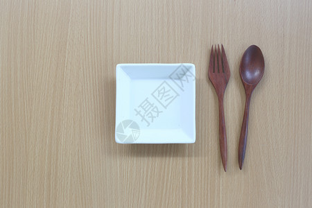 木勺和白碗放在设计概念食物的木材背景顶端图片