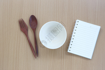厨房用具和关于木材背景的说明书用于设计食品概念图片