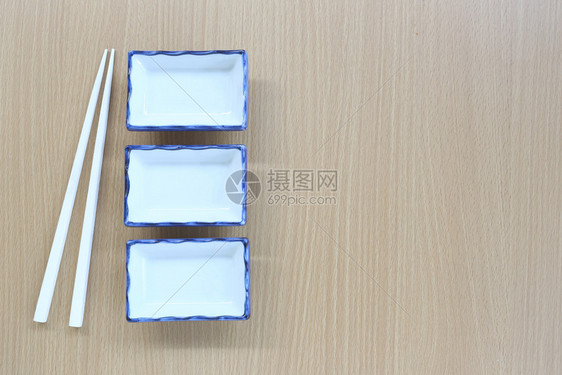 白筷子和碗放在设计概念食物的木材背景顶端视线上图片