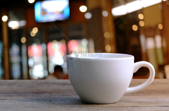 咖啡店木制桌上的白咖啡杯图片