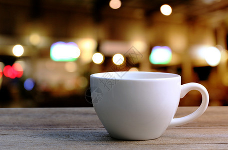 咖啡店木制桌上的白咖啡杯图片