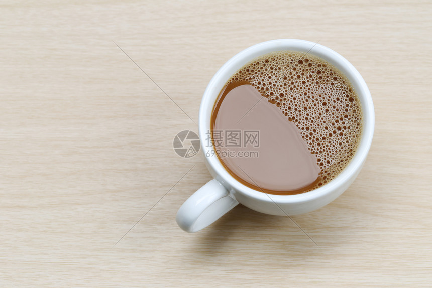 咖啡店的木制桌子上白咖啡杯中热图片