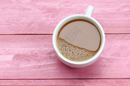 咖啡店粉红木桌上的白咖啡杯中热图片