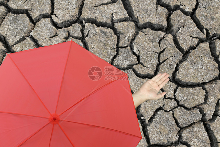 红伞和一只手站在裂开的大地上手伸到半径外以确定是否下雨图片