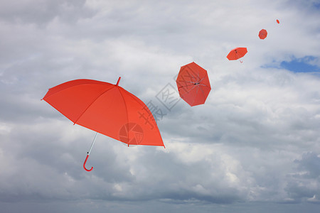 红伞被风吹散管理商业概念的有关雨云背景图片