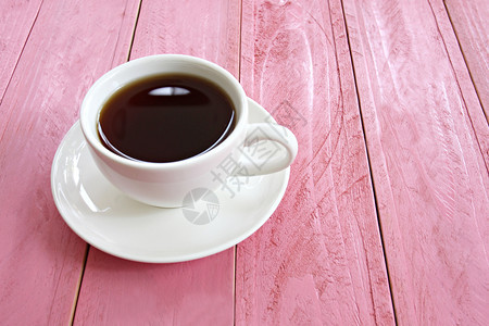 咖啡店的粉红色木桌上白咖啡杯中热图片