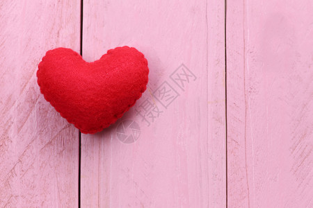 红心被放在情人节的爱粉红色木地板上图片