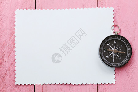粉红色木地板上的指南针和纸旅行出的概念图片