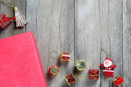红礼品盒和圣诞装饰设备在木制地板上并有复制空间图片