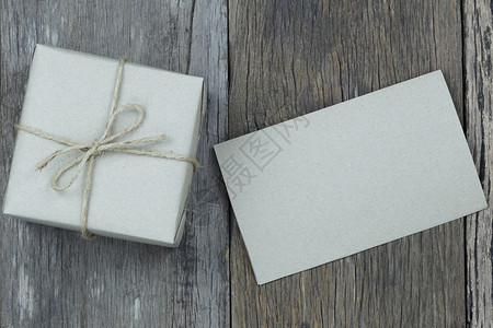 棕色礼品盒和木制地板上的空白纸并具有用于设计圣诞概念的复制空间图片