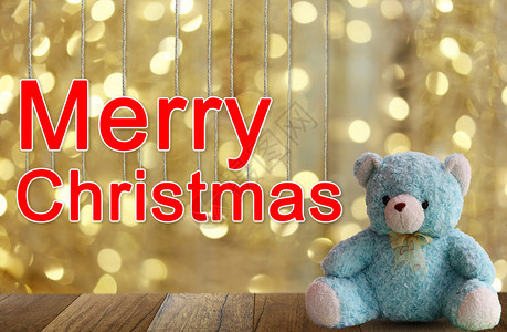蓝熊和圣诞文字在木制地板上和金布基背景用于设计圣诞节装饰概念图片