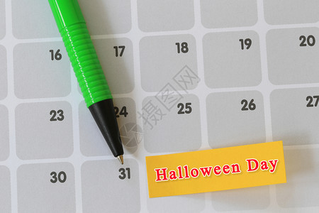 绿笔指在第31天的日历纸上并有万圣节的文本设计您节日的概念图片
