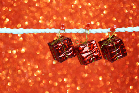 红礼盒挂在衣服上bokeh背景上设计你的圣诞概念图片