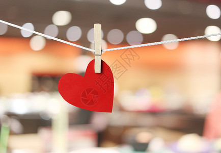 红纸心挂在绳子上情人节的概念和餐厅bokeh背景图片