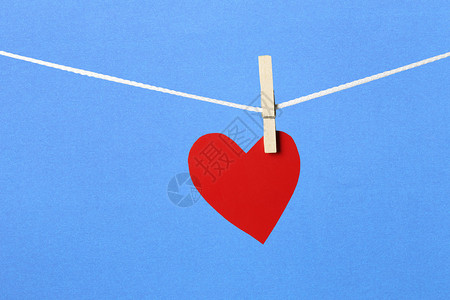 蓝色火鸡红纸心挂在绳子上情人节的概念和蓝背景背景