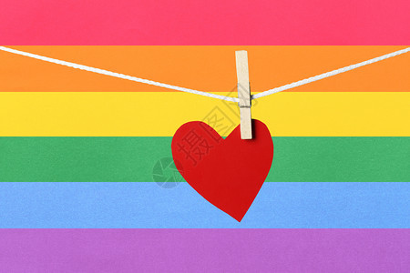 红纸心挂在情人节概念和多彩背景的绳索上图片
