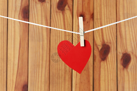 红纸心挂在绳子上情人节的概念和棕色木制背景图片