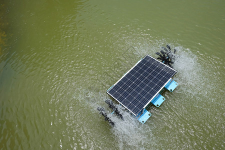 池塘中的太阳能水涡轮机和工作给水增加氧气图片
