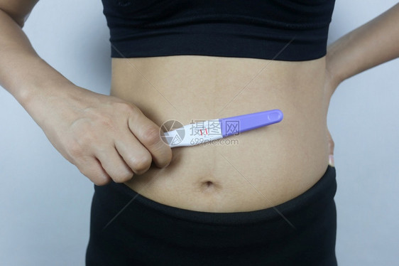 妇女手中的怀孕测试工具检结果显示怀孕身着黑衣的妇女图片