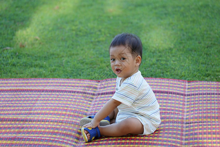 亚裔男孩坐在花园里可爱的幼儿图片
