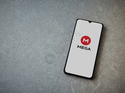 以色列洛德20年7月8日MEGAApp的发射屏在陶瓷石头背景上显示一个黑色移动智能手机带有标志顶端的视图平面有复制空间图片